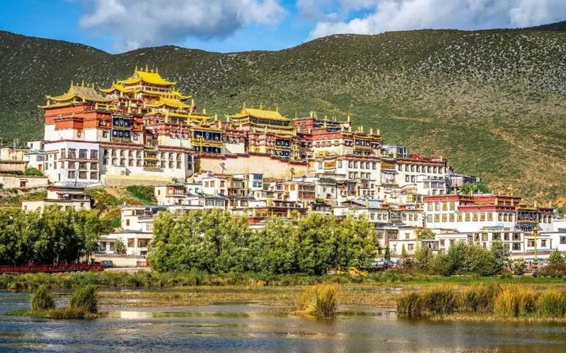 Songzanlin Monastery in Shangri-La, its golden roofs above the lake shore