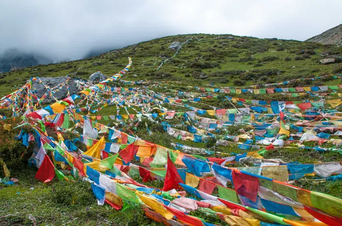 Prayer flags strung across a green grassland hill at Tagong in western Sichuan, on the road from Kangding to Daocheng